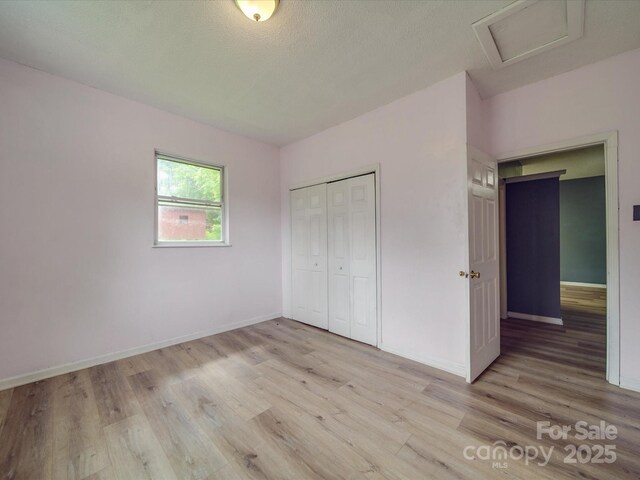 2440 Myers St, Gastonia, NC 28056 - unfurnished bedroom featuring attic access, light wood-style floors, baseboards, and a closet