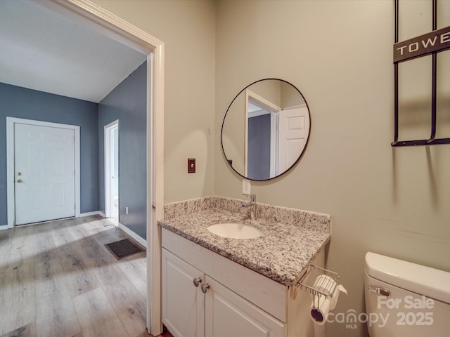 2440 Myers St, Gastonia, NC 28056 - half bathroom with vanity, toilet, wood finished floors, and baseboards