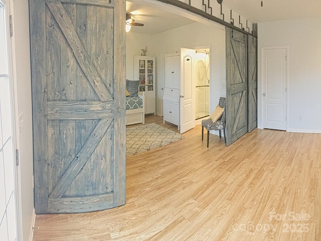 3416 Yarmouth Ln, Gastonia, NC 28056 - unfurnished room with a barn door, ceiling fan, wood finished floors, and baseboards