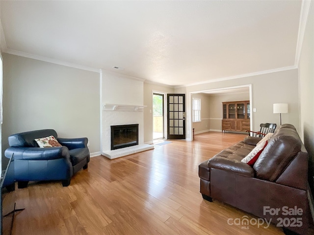 2619 Quailrush Rd, Charlotte, NC 28226 - living room featuring light wood-type flooring, ornamental molding, a brick fireplace, and baseboards