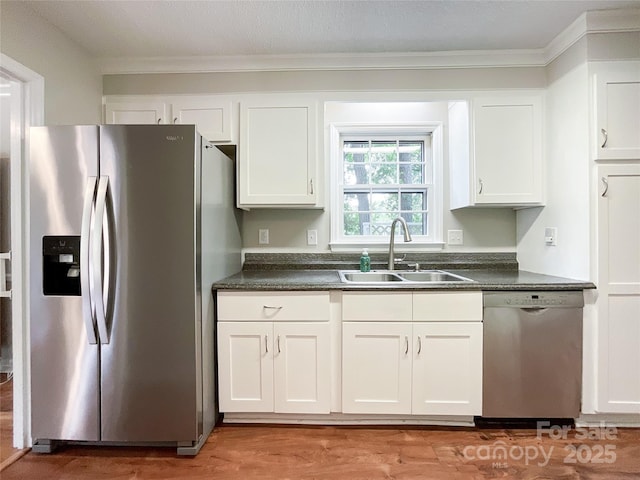 2619 Quailrush Rd, Charlotte, NC 28226 - kitchen with appliances with stainless steel finishes, a sink, dark countertops, white cabinets, and light wood-type flooring