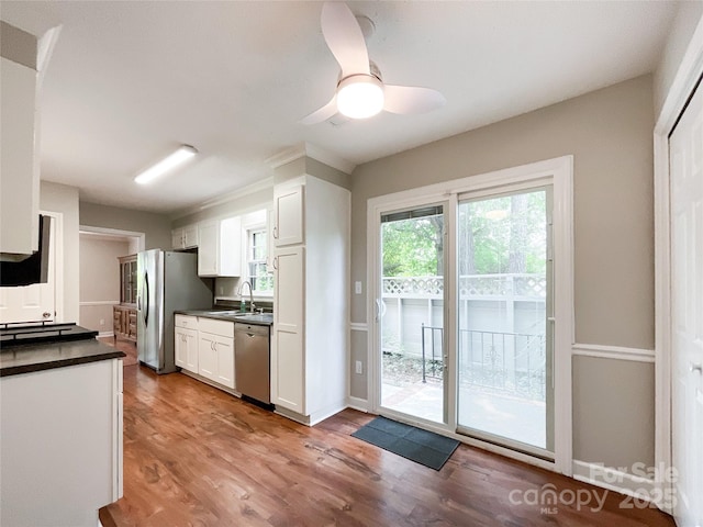 2619 Quailrush Rd, Charlotte, NC 28226 - kitchen featuring stainless steel appliances, dark countertops, a sink, white cabinetry, and light wood finished floors