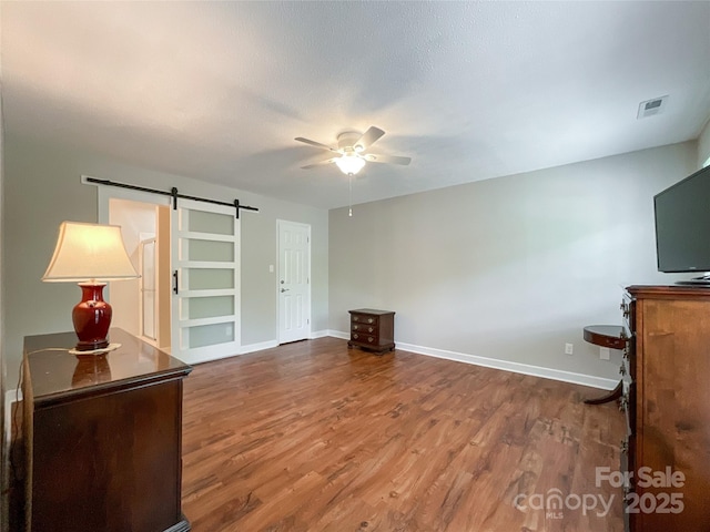 2619 Quailrush Rd, Charlotte, NC 28226 - unfurnished living room with a barn door, ceiling fan, wood finished floors, and baseboards