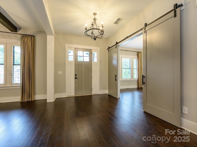 9426 Greyson Ridge Dr, Charlotte, NC 28277 - foyer with a barn door, a chandelier, dark wood-style floors, and baseboards