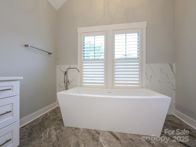 9426 Greyson Ridge Dr, Charlotte, NC 28277 - full bathroom with a freestanding tub, tile walls, a wainscoted wall, lofted ceiling, and baseboards