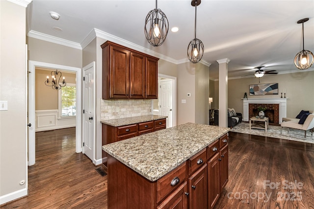 4637 Shannamara Dr, Matthews, NC 28104 - kitchen with a ceiling fan, dark wood-style floors, a fireplace, light stone counters, and crown molding