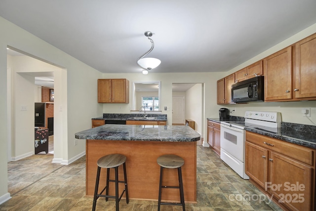 842 Cherry Rd S, Rock Hill, SC 29732 - kitchen with white electric range oven, black microwave, a kitchen island, stone finish floors, and a breakfast bar