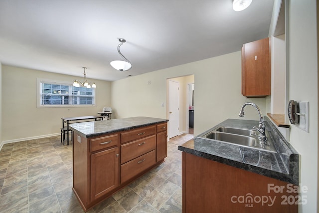 842 Cherry Rd S, Rock Hill, SC 29732 - kitchen with dark countertops, a chandelier, a kitchen island, brown cabinetry, and stone finish floors
