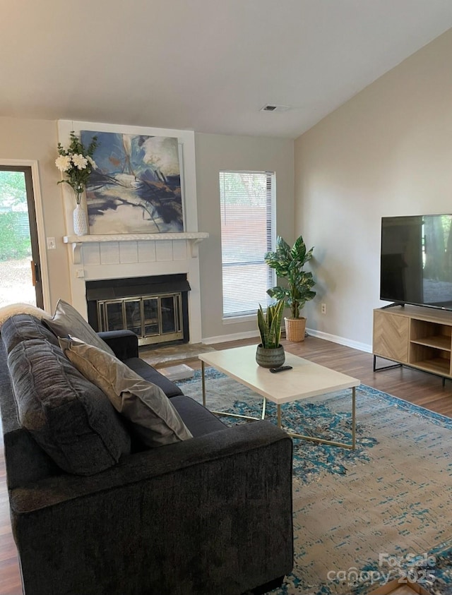 11421 Kingfisher Dr, Charlotte, NC 28226 - living area featuring wood finished floors, a glass covered fireplace, baseboards, and healthy amount of natural light