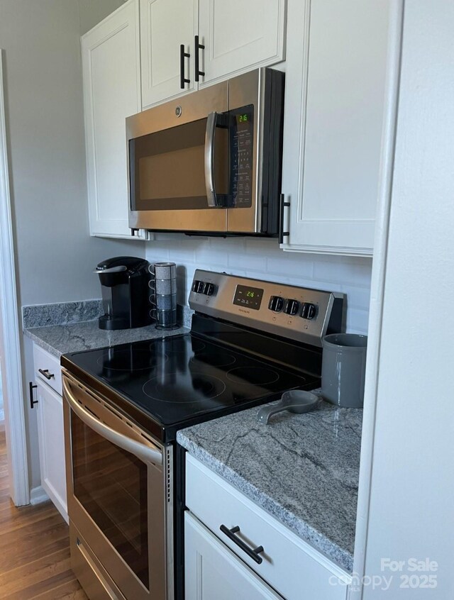 11421 Kingfisher Dr, Charlotte, NC 28226 - kitchen with appliances with stainless steel finishes, white cabinets, and wood finished floors