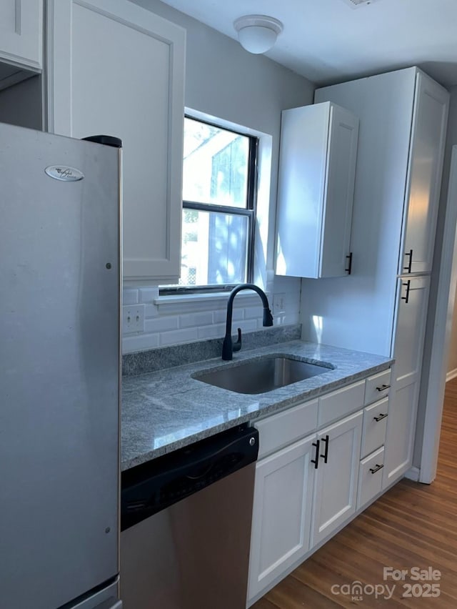 11421 Kingfisher Dr, Charlotte, NC 28226 - kitchen with stainless steel appliances, a sink, dark wood finished floors, light stone counters, and white cabinetry