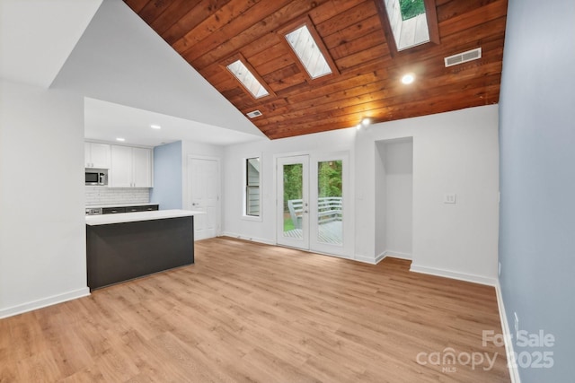 8338 Rittenhouse Cir, Charlotte, NC 28270 - unfurnished living room featuring a skylight, baseboards, light wood-type flooring, recessed lighting, and high vaulted ceiling