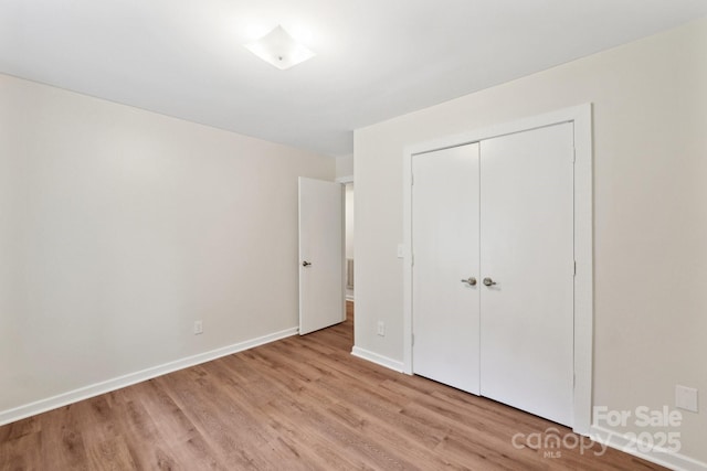 8338 Rittenhouse Cir, Charlotte, NC 28270 - unfurnished bedroom with light wood-type flooring, a closet, and baseboards