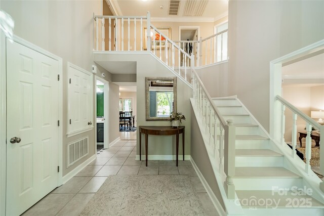 9920 White Cascade Dr, Charlotte, NC 28269 - stairs featuring a high ceiling, tile patterned floors, crown molding, and baseboards