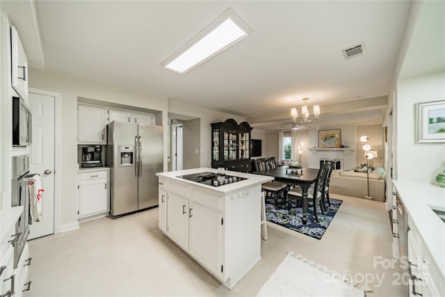 9920 White Cascade Dr, Charlotte, NC 28269 - kitchen featuring stainless steel refrigerator with ice dispenser, black electric stovetop, a center island, light countertops, and white cabinetry