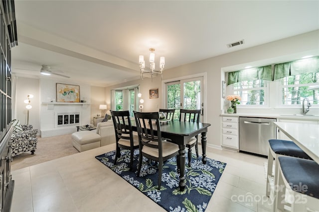 9920 White Cascade Dr, Charlotte, NC 28269 - dining space with light tile patterned flooring, a large fireplace, and a ceiling fan