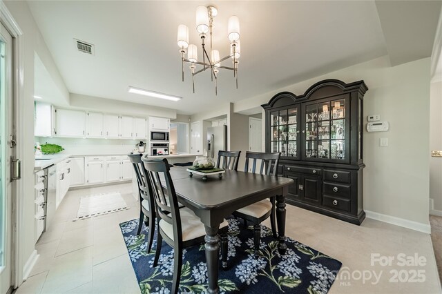 9920 White Cascade Dr, Charlotte, NC 28269 - dining room with a chandelier, light tile patterned floors, and baseboards