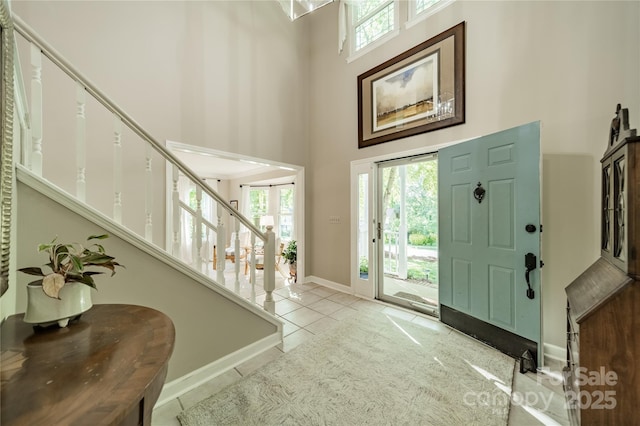 9920 White Cascade Dr, Charlotte, NC 28269 - entrance foyer with a towering ceiling, stairway, tile patterned flooring, and baseboards