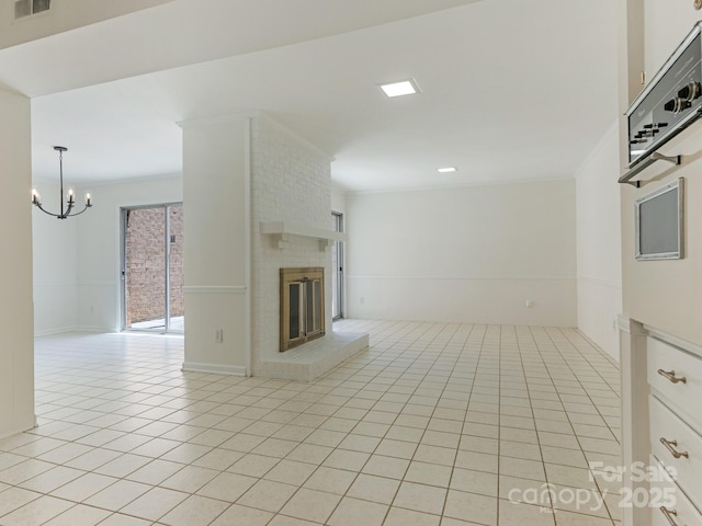 6817 Dumbarton Dr, Charlotte, NC 28210 - spare room with a chandelier, light tile patterned floors, a brick fireplace, and crown molding