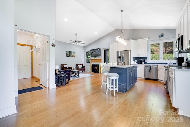 21 Kylie Grace Ln, Candler, NC 28715 - kitchen with stainless steel appliances, white cabinetry, a kitchen island, open floor plan, and high vaulted ceiling