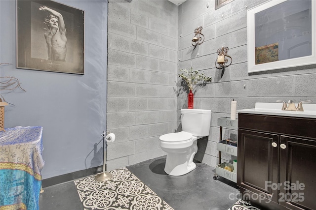 267 Ikerd Dr SE, Concord, NC 28025 - half bathroom with vanity, concrete block wall, and finished concrete floors