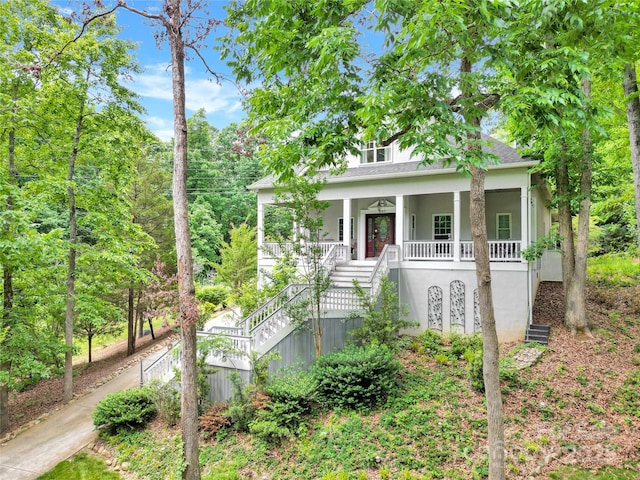 267 Ikerd Dr SE, Concord, NC 28025 - view of front of home with stairs, covered porch, stucco siding, and a shingled roof