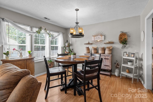 716 Mooresville Rd, Salisbury, NC 28144 - dining room featuring a textured ceiling, light wood-style flooring, a chandelier, and baseboards