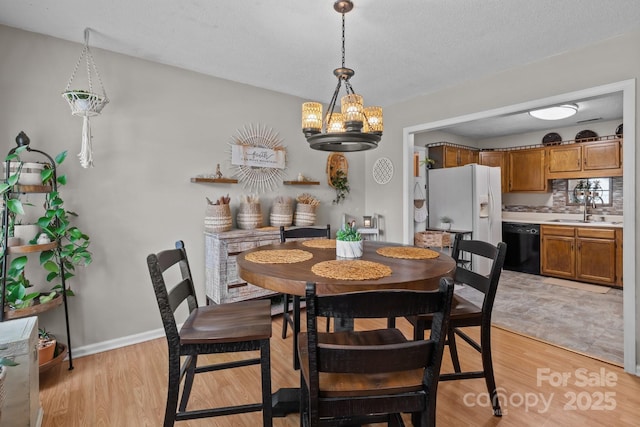 716 Mooresville Rd, Salisbury, NC 28144 - dining area with a chandelier, light wood finished floors, and baseboards