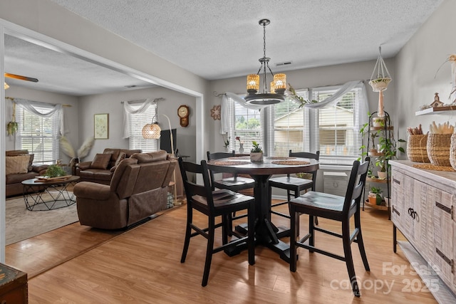716 Mooresville Rd, Salisbury, NC 28144 - dining space with a textured ceiling, a chandelier, healthy amount of natural light, and light wood-style floors