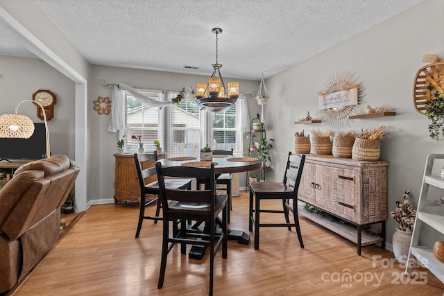 716 Mooresville Rd, Salisbury, NC 28144 - dining space featuring a textured ceiling, light wood-style flooring, a chandelier, and baseboards