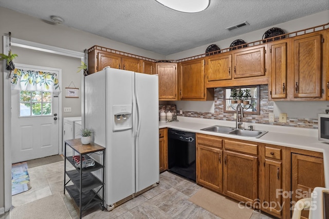 716 Mooresville Rd, Salisbury, NC 28144 - kitchen featuring black dishwasher, a sink, white refrigerator with ice dispenser, independent washer and dryer, and brown cabinets