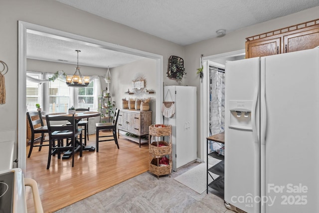 716 Mooresville Rd, Salisbury, NC 28144 - kitchen with white fridge with ice dispenser, a textured ceiling, a chandelier, freestanding refrigerator, and decorative light fixtures
