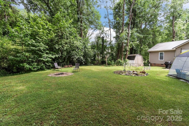716 Mooresville Rd, Salisbury, NC 28144 - view of green lawn with a fire pit and view of wooded area