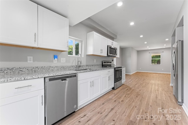 146 Georgia St SW, Concord, NC 28025 - kitchen with appliances with stainless steel finishes, white cabinetry, recessed lighting, light wood-style flooring, and light stone counters
