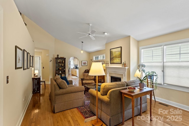 40 Avonlea Ln, Flat Rock, NC 28731 - living room with wood finished floors, ceiling fan, a fireplace, baseboards, and vaulted ceiling
