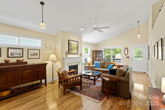 40 Avonlea Ln, Flat Rock, NC 28731 - living room featuring light wood-style floors, ceiling fan, a lit fireplace, baseboards, and vaulted ceiling