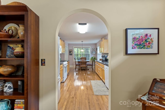 40 Avonlea Ln, Flat Rock, NC 28731 - kitchen featuring arched walkways, white appliances, light wood-style flooring, hanging light fixtures, and dark countertops