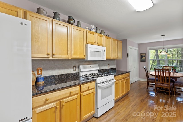 40 Avonlea Ln, Flat Rock, NC 28731 - kitchen featuring white appliances, decorative backsplash, light wood-style flooring, baseboards, and dark stone countertops