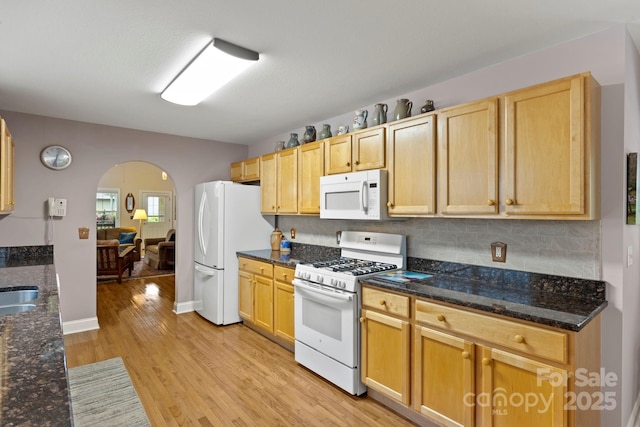 40 Avonlea Ln, Flat Rock, NC 28731 - kitchen with white appliances, arched walkways, light wood-style flooring, decorative backsplash, and dark stone counters
