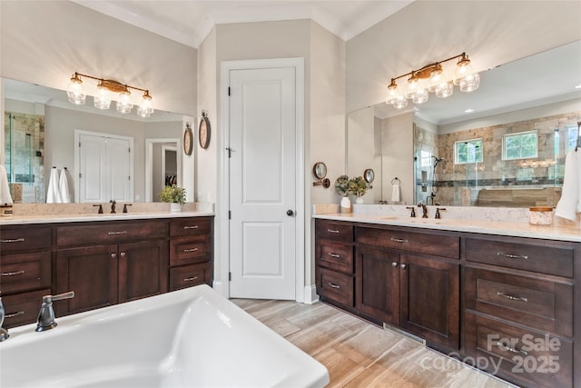 9125 Dylan Ridge Ct, Concord, NC 28027 - bathroom featuring a shower stall, a freestanding bath, two vanities, and crown molding