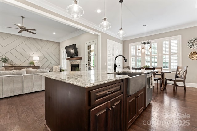 9125 Dylan Ridge Ct, Concord, NC 28027 - kitchen with a sink, open floor plan, dark brown cabinetry, a fireplace, and crown molding