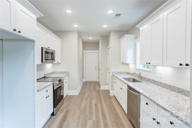 501 Old Speedway Dr NW Unit 1, Concord, NC 28027 - kitchen featuring a sink, appliances with stainless steel finishes, baseboards, light wood-style flooring, and decorative backsplash