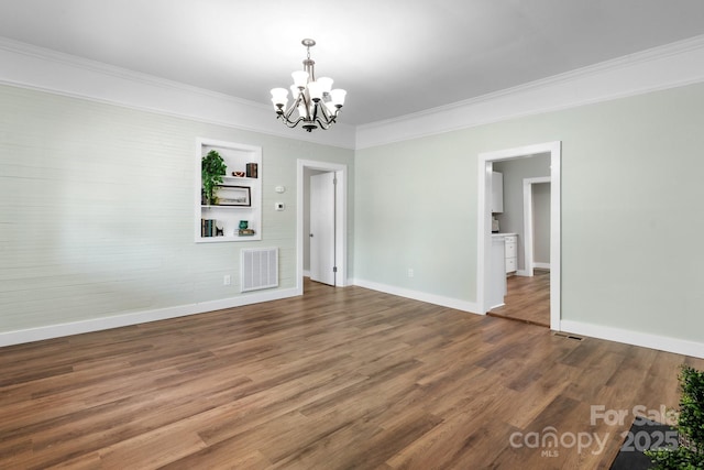73 20th Ave SW, Hickory, NC 28602 - spare room featuring a chandelier, baseboards, crown molding, wood finished floors, and built in features