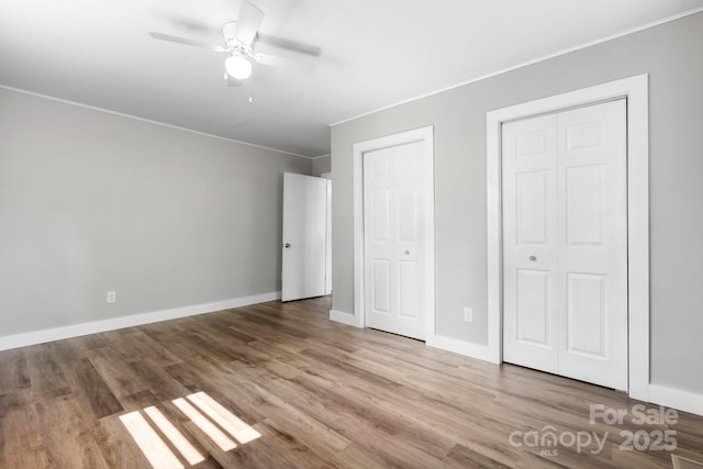 73 20th Ave SW, Hickory, NC 28602 - unfurnished bedroom with wood finished floors, multiple closets, ornamental molding, baseboards, and ceiling fan