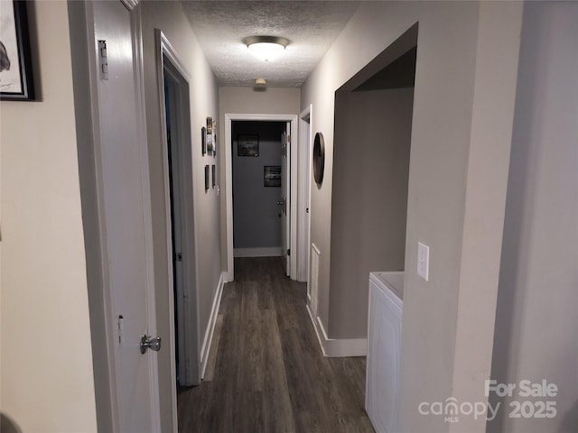 500 Bob Rollins Rd, Forest City, NC 28043 - corridor with a textured ceiling, dark wood-style flooring, baseboards, and washing machine and clothes dryer