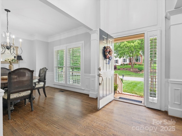 2821 Providence Spring Ln, Charlotte, NC 28270 - entrance foyer featuring a decorative wall, a chandelier, ornamental molding, wainscoting, and wood finished floors