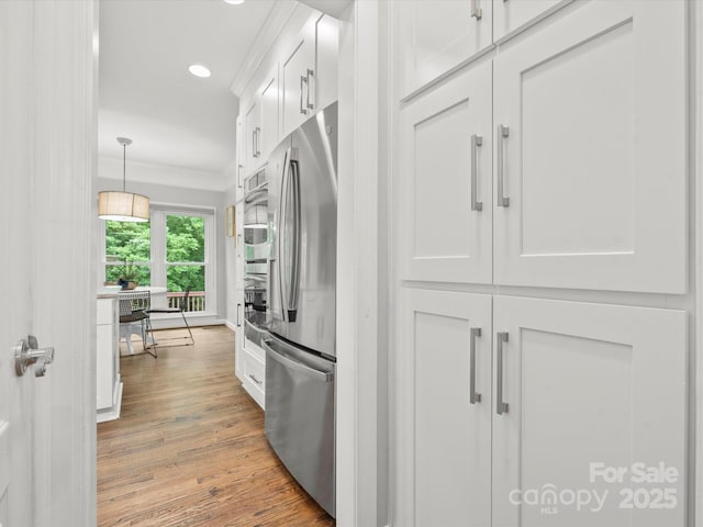 2821 Providence Spring Ln, Charlotte, NC 28270 - kitchen featuring appliances with stainless steel finishes, white cabinetry, light wood-style floors, crown molding, and recessed lighting