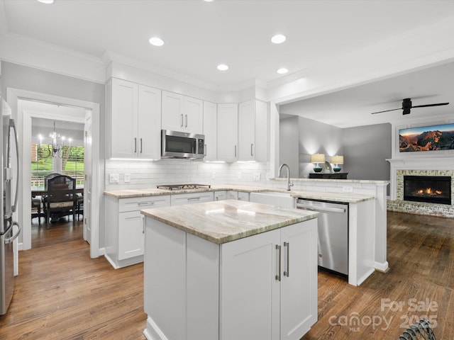 2821 Providence Spring Ln, Charlotte, NC 28270 - kitchen with appliances with stainless steel finishes, a sink, open floor plan, a peninsula, and wood finished floors