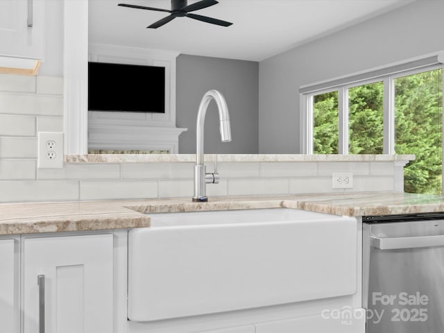 2821 Providence Spring Ln, Charlotte, NC 28270 - detailed view of dishwasher, a sink, backsplash, a ceiling fan, and white cabinets