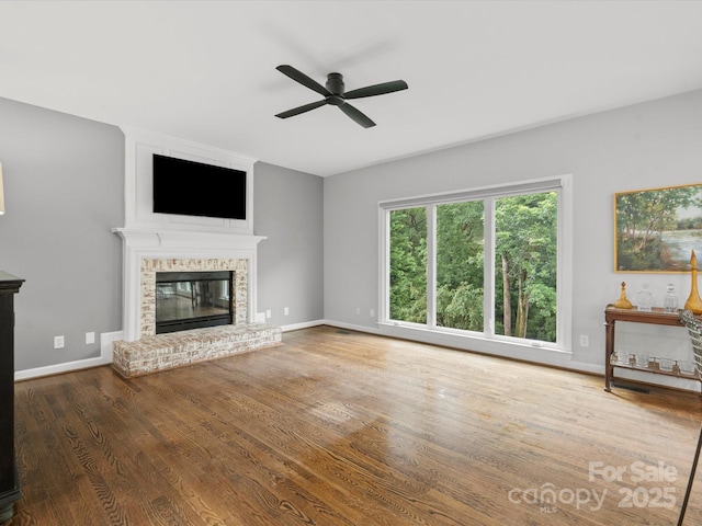2821 Providence Spring Ln, Charlotte, NC 28270 - unfurnished living room with ceiling fan, a brick fireplace, wood finished floors, and baseboards